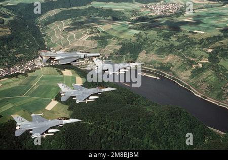 Drei F-16C Kampfflugzeuge und ein F-4G Phantom II Wild Weasel fliegen über den Rhein. Die Kampffalken sind mit AGM-88-HARM-Raketen und AIM-9-Sidewinder-Raketen bewaffnet, während eine HARM-Rakete auf dem Wilden Wiesel sichtbar ist. Die F-16s repräsentiert die taktische Kampfeinheit 81. und die Flugzeugstaffel 23. Generation, mit dem führenden Flugzeug des Kommandanten, 52. Taktischer Kampfflugflügel. Die F-4G ist vom taktischen Kampfgeschwader 480. Land: Bundesrepublik Deutschland Stockfoto