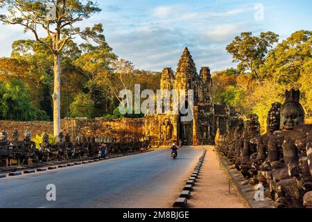 SIEM REAP, 11. JANUAR 2023: Motorräder auf der Brücke zum Südtor von Angkor Thom, Kambodscha Stockfoto