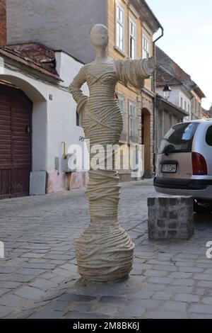 Statue einer Dame bedeckt mit Seilen am Eingang zur Strada Sforii (Seilstraße). Die schmalste Straße von Brașov Rumänien; eine der schmalsten in Europa Stockfoto