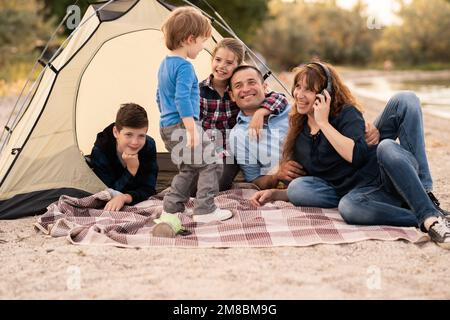 Camping, Reisen, Tourismus, Wandern und Menschen Konzept. Große Familie mit drei Kindern, die einen Campingurlaub auf dem Land genießen. Speicherplatz kopieren Stockfoto