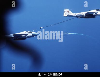 Eine Luftaufnahme eines Angriffsgeschwaders 176 (VA-176) A-6E links, während es sich der Betankungsdroge nähert, die hinter einem KA-6D-Eindringflugzeug aus demselben Geschwader eingesetzt wurde. Unter den beiden Flugzeugen befindet sich der Flugzeugträger USS FORRESTAL (CV-59). Land: Atlantik (AOC) Stockfoto