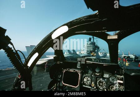 Aus dem Cockpit eines Angriffsgeschwaders 176 (VA-176) KA-6D sieht man, dass ein Flugdirektor einen Piloten über das überfüllte Cockpit des Flugzeugträgers USS FORRESTAL (CV 59) führt. Land: Atlantik (AOC) Stockfoto