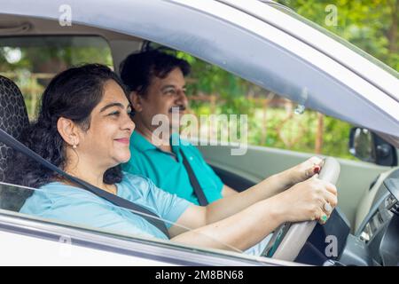 Glückliche, reife indianerin, die mit ihrem Mann Auto in der Stadt fährt. Stockfoto