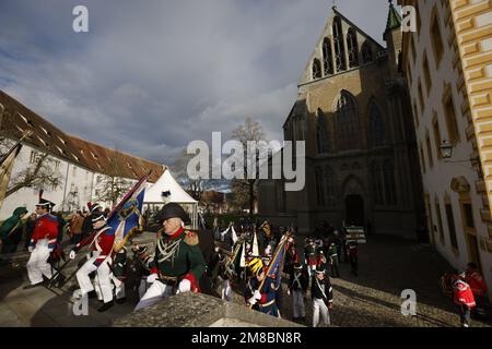 Salem, Deutschland. 13. Januar 2023. Gruppen in traditionellen Kostümen gehen am Tag der zweiten Beerdigung von Max Margrave von Baden über den Vorplatz von Salem Minster. Der Bestattungsservice richtet sich an den Familienkreis, freundliche Häuser und Vertreter aus Politik, Wirtschaft und Kultur. Der Margrave starb am 29. Dezember im Alter von 89 Jahren im Schloss Salem am Bodensee. Kredit: Philipp von Ditfurth/dpa/Alamy Live News Stockfoto