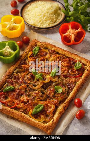 Hausgemachter Blätterkuchen mit Pesto, Tomaten, Paprika und Mozzarella. Stockfoto