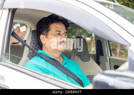 Ein glücklicher, reifer indianer, der Auto fährt, in der Stadt, im häuslichen Leben. Personen- und Sicherheitskonzept. Stockfoto