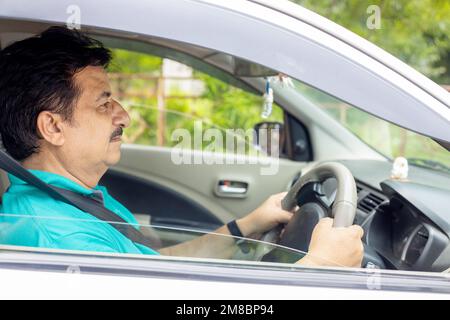 Ein glücklicher, reifer indianer, der Auto fährt, in der Stadt, im häuslichen Leben. Personen- und Sicherheitskonzept. Stockfoto