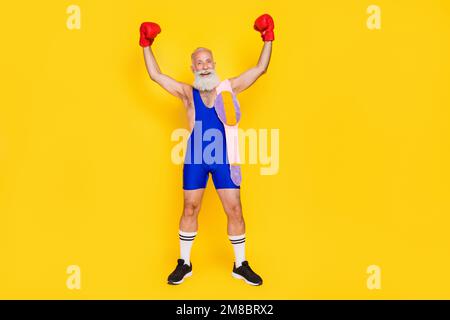 Großes Porträt von begeistert aufgeregten Großvätern Fäuste tragen Boxhandschuhe feiern Triumph isoliert auf gelbem Hintergrund Stockfoto