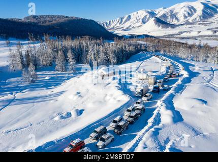 (230113) -- ALTAY, 13. Januar 2023 (Xinhua) -- Dieses Luftfoto zeigt Autos, die in das Winterresort Hemu in der Präfektur Altay, Nordwest-Chinas Autonome Region Xinjiang Uygur, 12. Januar 2023 einfahren. Die Präfektur Altay ist bekannt für ihre lange Wintersaison, die bis zu acht Monate pro Jahr dauern kann. Mit seinem weitläufigen natürlichen Pulverschnee zieht es Skifahrer weltweit an. Die Region hat sich in den letzten Jahren bemüht, den Wintertourismus anzukurbeln und Besucher mit Skifahren, Eisangeln und anderen Winteraktivitäten zu verführen. Zwischen dem 2022. Dezember und dem 11. Januar 2023 wurden rund 1,02 Millionen Touristen aufgenommen. (Xinhua/Hu Huhu Stockfoto