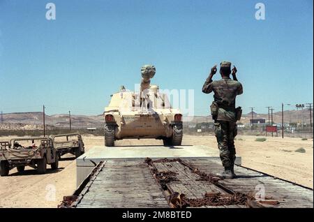 Ein Soldat der 24. Infanteriedivision (mechanisiert) führt einen selbstfahrenden M-109 155mm-Haubitzer auf ein Plattwagen auf dem Yermo-Bahnhof, nachdem die Einheit zum National Training Center in Fort Irwin gewechselt ist. Exaktes Datum Aufnahme Unbekannt. Basis: Yermo Bundesstaat: Kalifornien (CA) Land: Vereinigte Staaten von Amerika (USA) Stockfoto