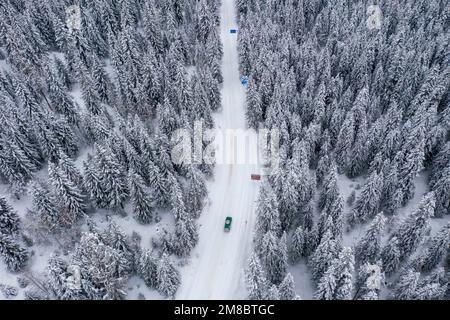 (230113) -- ALTAY, 13. Januar 2023 (Xinhua) -- Dieses Luftfoto wurde am 8. Januar 2023 aufgenommen und zeigt ein Fahrzeug, das in der malerischen Gegend von Kanas in der Präfektur Altay, Nordwestchina der Autonomen Region Xinjiang Uygur, fährt. Die Präfektur Altay ist bekannt für ihre lange Wintersaison, die bis zu acht Monate pro Jahr dauern kann. Mit seinem weitläufigen natürlichen Pulverschnee zieht es Skifahrer weltweit an. Die Region hat sich in den letzten Jahren bemüht, den Wintertourismus anzukurbeln und Besucher mit Skifahren, Eisangeln und anderen Winteraktivitäten zu verführen. Zwischen dem 2022. Dezember und dem 11. Januar 2023 wurden rund 1,02 Millionen Touristen aufgenommen. Xi Stockfoto