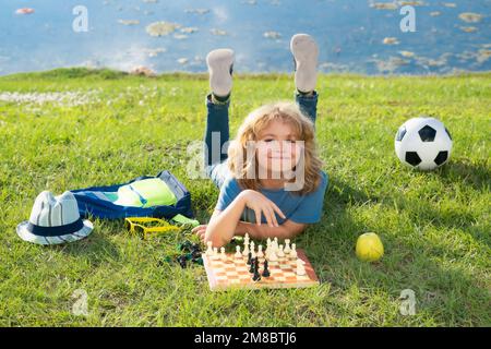 Schachspiel für Kinder. Kinder, die im Park Schach spielen. Stockfoto