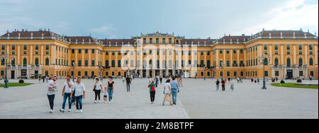 Wien, Österreich - 28. August 2022: Einige Personen gehen am Platz vorbei, der zum Eingang zum Schloss Schönbrunn in Wien führt, Österreich, in einem Pano Stockfoto