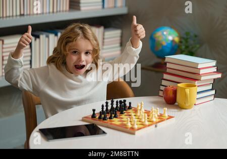 Ein kluger, aufgeregter, überraschter Junge, der Schach spielt. Stockfoto