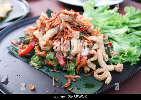 Würziger Salat, Griebensalat vom Schwein oder Salat mit Schweineschale oder würziger Salat aus Thailand oder Teeblätter zum Servieren Stockfoto