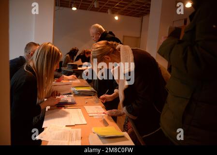 Brüssel, Belgien. 13. Januar 2023. Eine Frau meldet sich während der ersten Runde der Präsidentschaftswahlen in der tschechischen Botschaft in Brüssel am 13. Januar 2023 bei der wahlkommission an. Kredit: Petr Kupec/CTK Photo/Alamy Live News Stockfoto