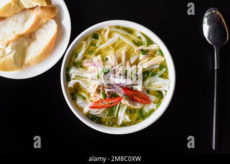 Hühnersuppe Pho ga im vietnamesischen Stil auf schwarzem Hintergrund Stockfoto