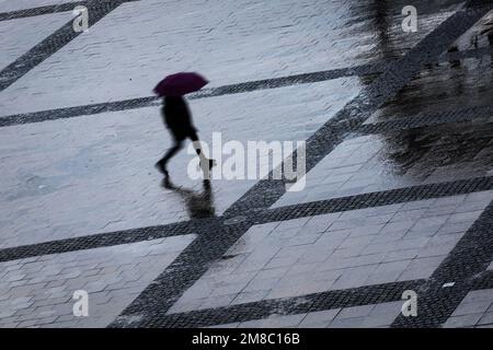 Hamburg, Deutschland. 13. Januar 2023. Passanten gehen bei Regen und Sturm durch den Rathausplatz im Stadtzentrum. Kredit: Christian Charisius/dpa/Alamy Live News Stockfoto