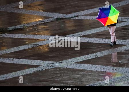 Hamburg, Deutschland. 13. Januar 2023. Eine Frau geht mit ihrem Regenschirm, der vom Sturm umgestoßen wurde, durch den Rathausplatz im Stadtzentrum. Kredit: Christian Charisius/dpa/Alamy Live News Stockfoto