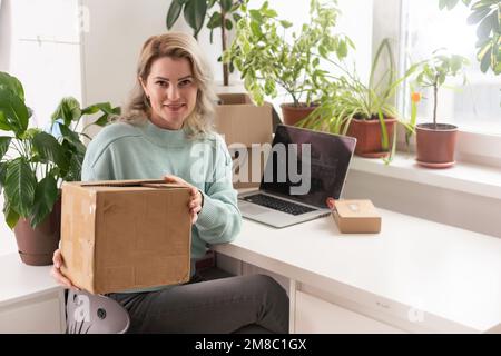 Nahaufnahme eines weiblichen Online-Shops, Inhaber eines kleinen Unternehmens, Unternehmer, der Verpackungspakete nach dem Versand vorbereiteter Versandkarton auf dem Tisch vorbereitet Stockfoto