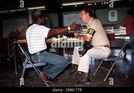 Ein FBI-Agent nimmt einen Bericht in der Joint Army/FBI/US Marshal taktischen Operationszentrale für Strafverfolgung auf, die eingerichtet wurde, um mit den Folgen des Hurricane Hugo fertig zu werden. Basis: Saint Croix Bundesstaat: Jungferninseln (VI) Land: Vereinigte Staaten von Amerika (USA) Stockfoto