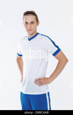 Fußballspieler in weiß-blauer Uniform vor weißem Hintergrund Stockfoto