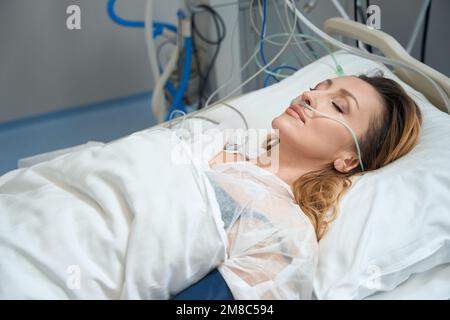 Hübsche Frau liegt auf der Intensivstation in der Klinik Stockfoto