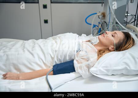 Hübsche Frau liegt auf der Intensivstation in der Klinik Stockfoto