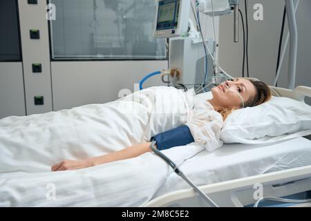 Hübsche Frau liegt auf der Intensivstation im Krankenhaus Stockfoto