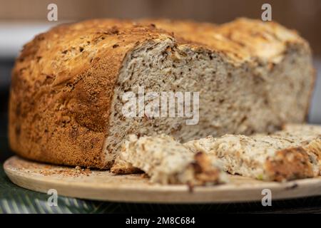 Leckeres hausgemachtes Brot mit goldener Kruste liegt auf einem Holzbrett Stockfoto