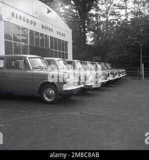 1959, historisch, Reihe neuer Ford Angiia 105E Autos vor der Garage, Hargood Motor Sales, Wilmslow Rd, East Didsbury, Parrs Wood, Manchester, England, Großbritannien. Die Anglia 105E mit ihrem neuen amerikanischen Stil war das vierte von Ford veröffentlichte Anglia-Modell und wurde von 1959 bis 1968 mit über einer Million gefertigten Maschinen produziert. Stockfoto