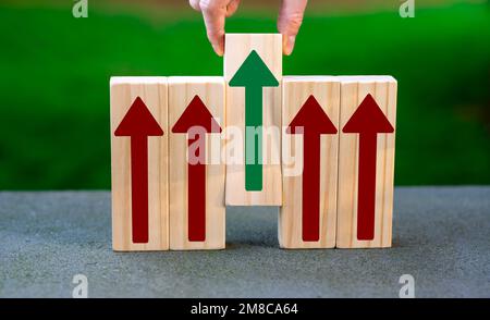 Holzblöcke mit Pfeilen nach oben. Auswahl eines Blocks per Hand. Symbol für die richtige Entscheidung. Stockfoto