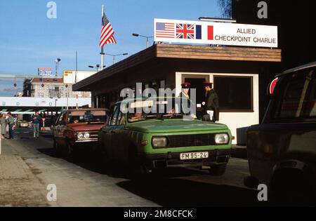 Ostdeutscher fahren mit ihrem Auto durch Checkpoint Charlie und nutzen die lockeren Reisebeschränkungen für einen Besuch in Westdeutschland. Basis: Berlin Land: Deutschland / Deutschland (DEU) Stockfoto