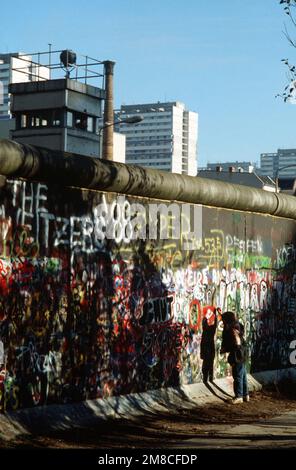 Ein westdeutsches Kind versucht, ein Stück der Berliner Mauer als Souvenir abzuschlagen. Ein Teil der Mauer wurde bereits am Potsdamer Platz abgerissen. Basis: Berlin Land: Deutschland / Deutschland (DEU) Stockfoto