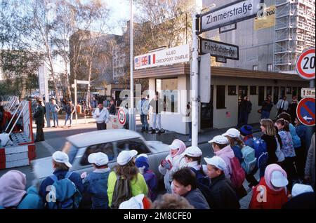 Ostdeutscher fahren mit ihrem Auto durch Checkpoint Charlie und nutzen die lockeren Reisebeschränkungen für einen Besuch in Westdeutschland. Basis: Berlin Land: Deutschland / Deutschland (DEU) Stockfoto