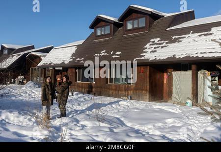 (230113) -- GENHE, 13. Jan. 2023 (Xinhua) -- Dieses Foto wurde am 13. Jan. 2023 aufgenommen und zeigt Juele mit seiner Familie in einer neuen Umzugsgemeinde in Aoluguya Ewenki, Genhe City in Nordchinas Autonomer Region der inneren Mongolei. Alle zwei oder drei Tage fährt Juele Bulituotian zum Jinhe-Waldgebiet etwa 80 Kilometer von Genhe City entfernt. Dort wird der 39-jährige Aoluguya Ewenki-Hirte, der einen traditionellen Pelzmantel trägt, sein forschendes Rentier finden. Anstatt Rentiere in einer Scheune zu halten, lassen die Ewenki-Hirten die Tiere im Wald leben und überprüfen sie alle paar Tage. Ju Stockfoto