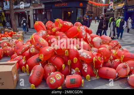 London, Großbritannien. 13. Januar 2023 Alte rote Laternen warten auf die Entfernung auf einer Straße in Chinatown, während Arbeiter vor dem chinesischen Neujahr, dem Jahr des Hasen, neue installieren. Kredit: Vuk Valcic/Alamy Live News Stockfoto