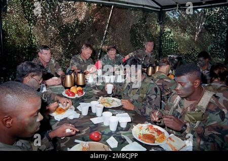 GENERAL Robert W. Riscassi, zweiter von rechts, stellvertretender STABSCHEF, USA Army und BGEN Craig Hagan, Zweiter von links, Assistant Division Commander, 25. Infanteriedivision (Light), sitzen am Haupttisch, während sie mit einigen der Truppen der Division auf dem Feld speisen. Basis: Schofield Barracks, Kaneohe Bay Bundesstaat: Hawaii (HI) Land: Vereinigte Staaten von Amerika (USA) Stockfoto