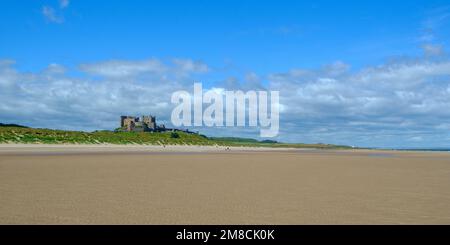 4. Juli 2022 - Bamburgh, Großbritannien: Das historische Bamburgh Castle am Horizont über Bamburgh Beach, Northumberland, Großbritannien, liegt in nordwestlicher Richtung Stockfoto
