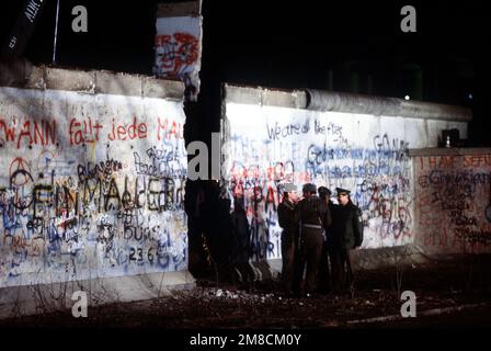 Ost- und westdeutsche Wachen unterhalten sich an der neu geschaffenen Öffnung der Berliner Mauer, nachdem ein Kran einen Teil des Bauwerks neben dem Brandenburger Tor entfernt hatte. Basis: Berlin Land: Deutschland / Deutschland (DEU) Stockfoto