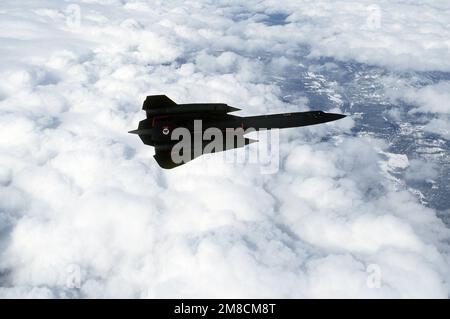 Air-to-Air-Ansicht rechte Seite, hoch, Ansicht eines 9. Strategic Reconnaissance Wings SR-71 Blackbird Aufklärungsflugzeugs, das über verstreute Wolken fliegt, auf einer Mission vom Beale Air Force Base, Kalifornien. Exaktes Datum Aufnahme Unbekannt. Land: Unbekannt Stockfoto