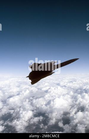 Air-to-Air-Ansicht rechte Seitenansicht des SR-71 Blackbird-Aufklärungsflugzeugs eines 9. Strategic Reconnaissance Wings, das sich über verstreute Wolken auf einer Mission vom Beale Air Force Base, Kalifornien, nach links bewegt. Exaktes Datum Aufnahme Unbekannt. Land: Unbekannt Stockfoto