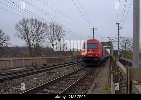Eine OBB Austrian Railways Siemens Eurorunner-Lokomotive mit Personenzug über die Ostbahnsteg-Brücke, Wien, Österreich Stockfoto