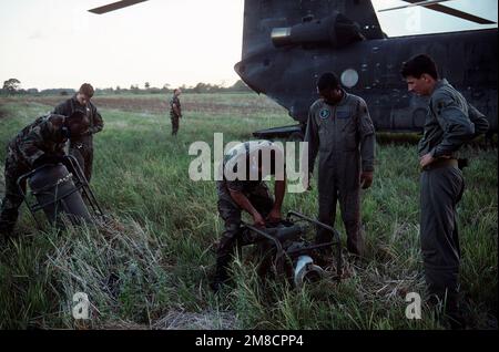 Soldaten stellten auf einem Feld neben einem Chinook-Hubschrauber der CH-47 während der Operation Just Cause Tankausrüstung auf. Die Soldaten sind vom 1. Bataillon, 228. Luftregiment. Betreff Operation/Serie: JUST CAUSE Base: David Country: Panama (PAN) Stockfoto