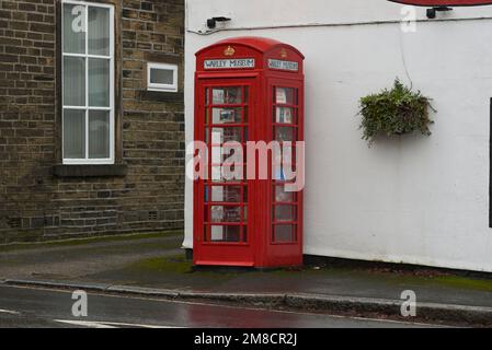 Warley Museum, das weltweit kleinste Museum in Warley Village in der Nähe von Halifax, West Yorkshire, Großbritannien, in einer alten Telefonzelle außerhalb des Maypole Inn Pub. Stockfoto