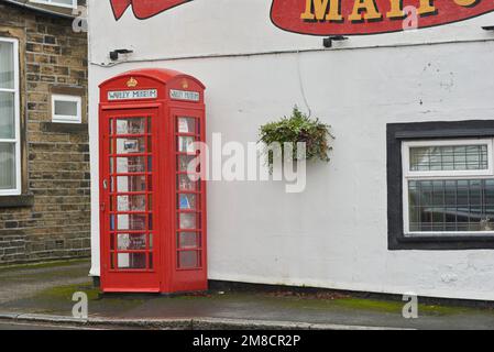 Warley Museum, das weltweit kleinste Museum in Warley Village in der Nähe von Halifax, West Yorkshire, Großbritannien, in einer alten Telefonzelle außerhalb des Maypole Inn Pub. Stockfoto