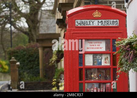 Warley Museum, das weltweit kleinste Museum in Warley Village in der Nähe von Halifax, West Yorkshire, Großbritannien, in einer alten Telefonzelle außerhalb des Maypole Inn Pub. Stockfoto