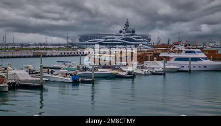 Die Skyline von Doha aus dem Box Park, ein Sonnenuntergang von Doha Katar mit Yachten und Dhows im arabischen Golf und Wolken am Himmel im Hintergrund. Stockfoto