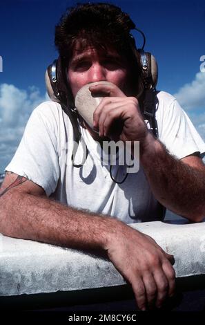 Aviation Boatswain's Mate E (Launch and Recovery Equipment) 2. Klasse John Insano kommuniziert mit anderen Besatzungsmitgliedern des Cockpits an Bord des nuklearbetriebenen Flugzeugträgers USS DWIGHT D. EISENHOWER (CVN-69), der vor der Küste Floridas unterwegs ist. Land: Atlantik (AOC) Stockfoto