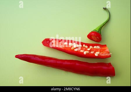 Frisch geschnittener roter Pfeffer auf einem grünen Schneidebrett Stockfoto